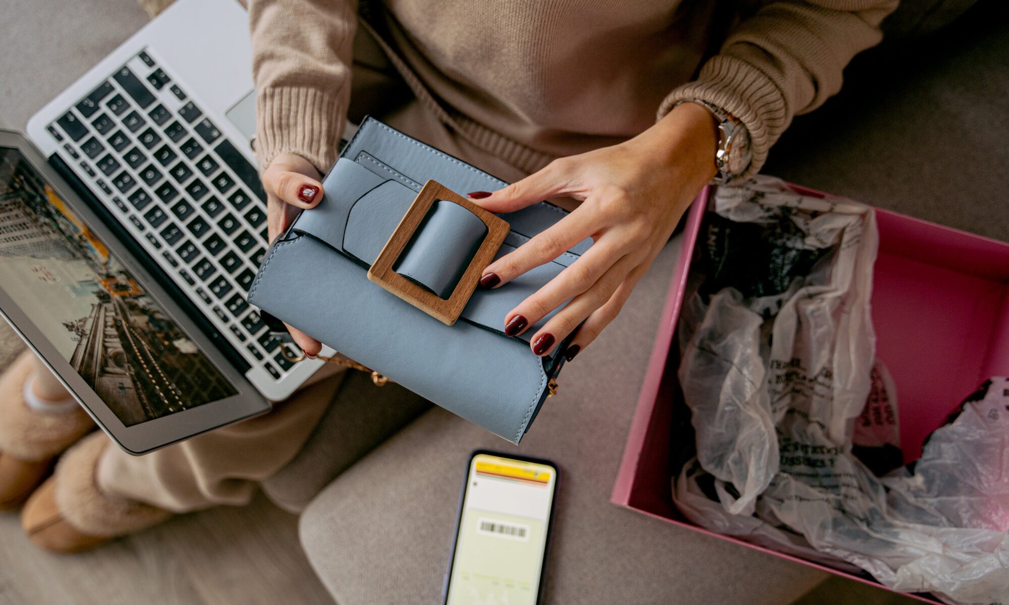 mujer tomando fotos de una cartera de mujer para subirlo a redes sociales